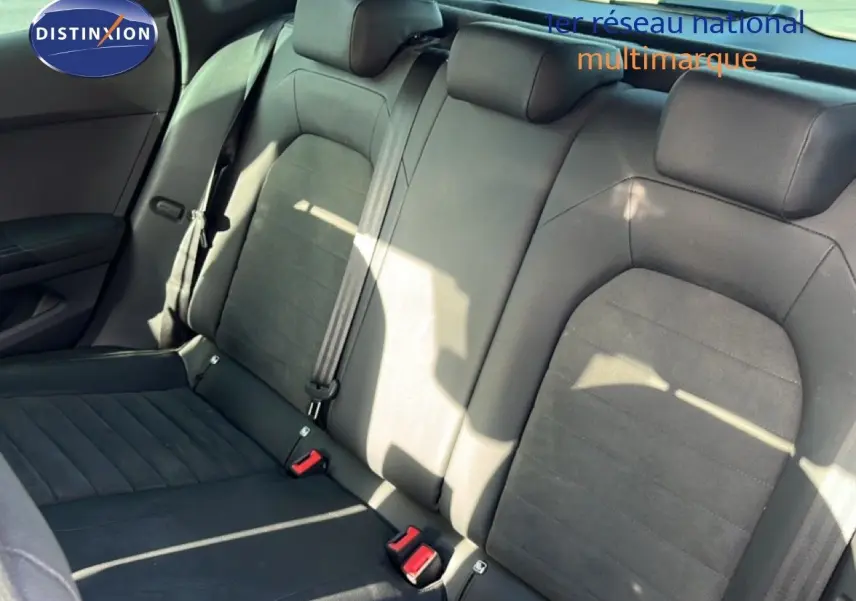 Vue intérieure des sièges arrière en tissu noir du SEAT Arona 2025, avec ceintures de sécurité visibles.