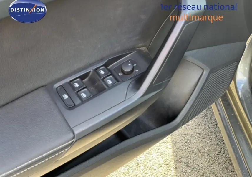 Gros plan sur la commande des vitres et rétroviseurs côté conducteur du SEAT Arona gris métallique.