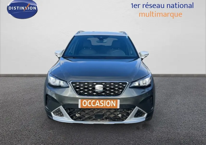 Vue frontale d'un SEAT Arona gris magnétique avec calandre noire et détails argentés, plaque "OCCASION" visible.