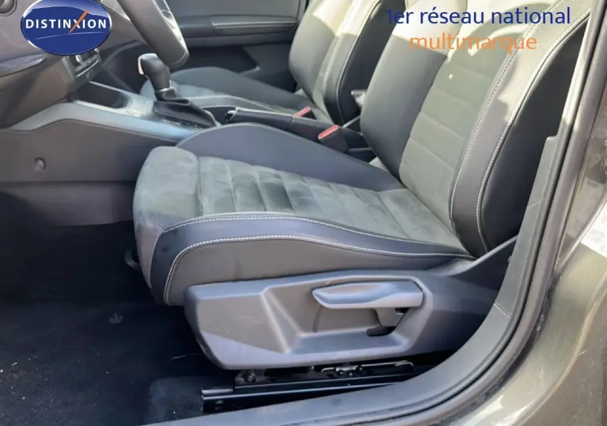 Vue intérieure côté conducteur du siège avant en tissu et cuir noir du SEAT Arona gris magnétique 2025 avec levier de vitesses automatique.