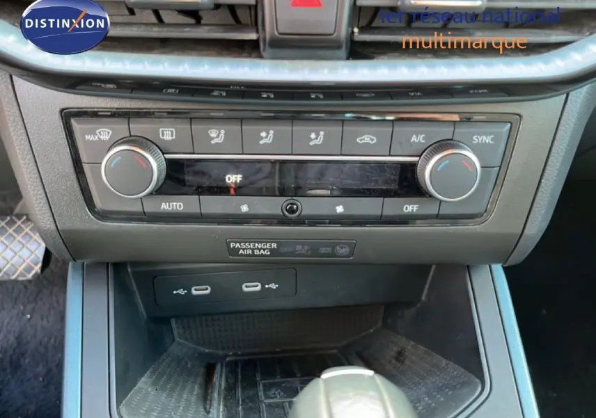 Vue rapprochée de la console centrale du SEAT Arona 2025, montrant les commandes de climatisation et ports USB.