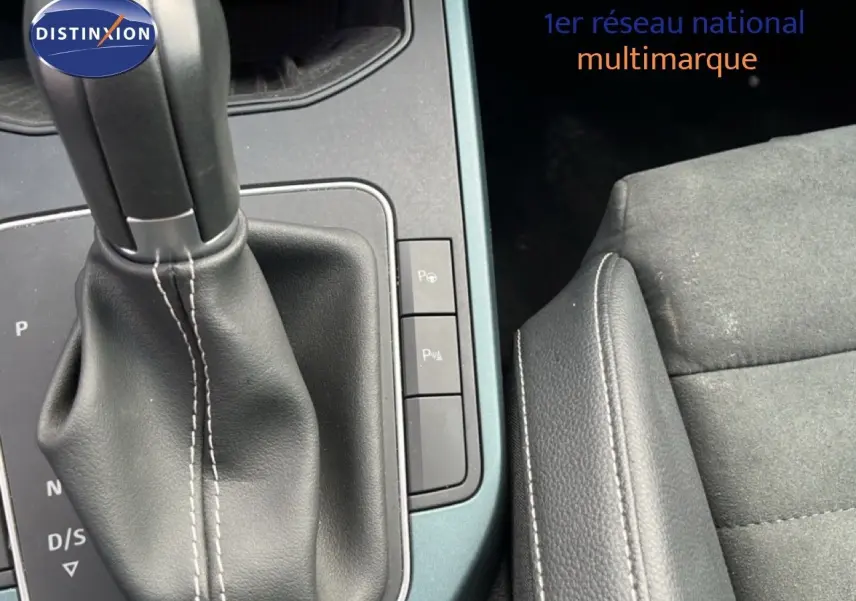 Gros plan sur la console centrale et levier de vitesse cuir noir de la SEAT Arona 2025, intérieur tissu gris et cuir.