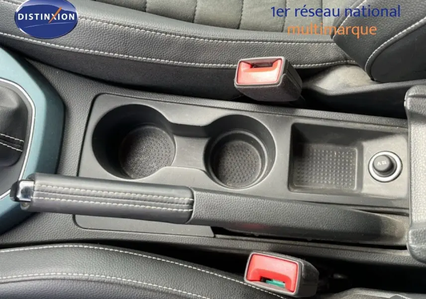 Vue intérieure centrée sur la console centrale avec frein à main, porte-gobelets et sellerie noire du SEAT Arona 2025.