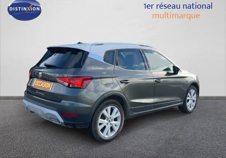 Vue 3/4 arrière droite d'un SEAT Arona gris magnétique avec toit noir et jantes alliage 17 pouces.