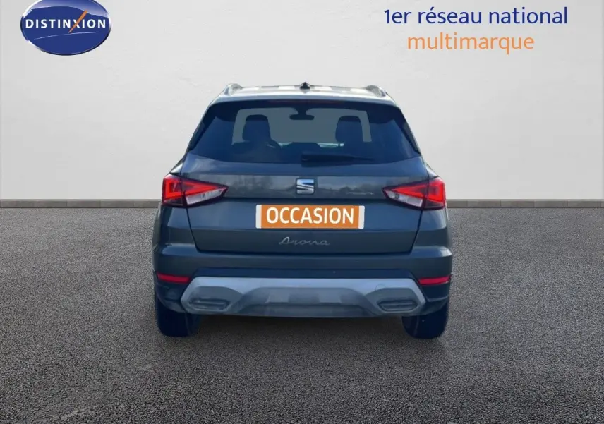 Vue arrière d'un SEAT Arona gris magnétique avec toit blanc, affichant une plaque "OCCASION" sur fond orange.