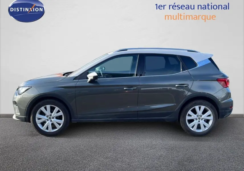 Vue latérale gauche d'un SEAT Arona gris magnétique avec toit blanc, roues alliage 17 pouces, sur fond neutre.