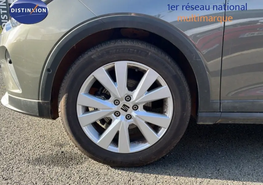 Gros plan sur la roue avant gauche d’un SEAT Arona gris magnétique, mettant en valeur la jante alliage 17 pouces.