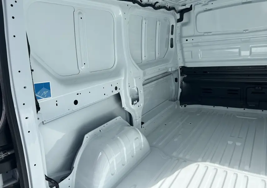 Vue intérieure côté gauche du coffre blanc du Renault Trafic Fourgon L1H1, montrant la cloison tôlée et l’espace de chargement.