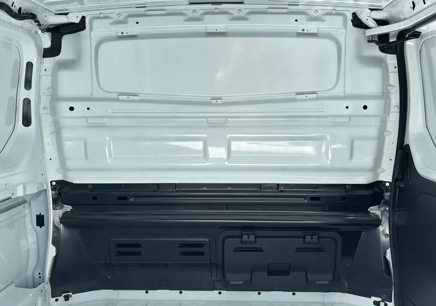Vue intérieure du Renault Trafic Fourgon L1H1 blanc, montrant la cloison tôlée séparant la cabine de la zone de chargement.