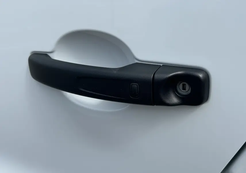 Poignée de porte noire en gros plan sur la porte blanche d'un Renault Trafic Fourgon L1H1 2026.