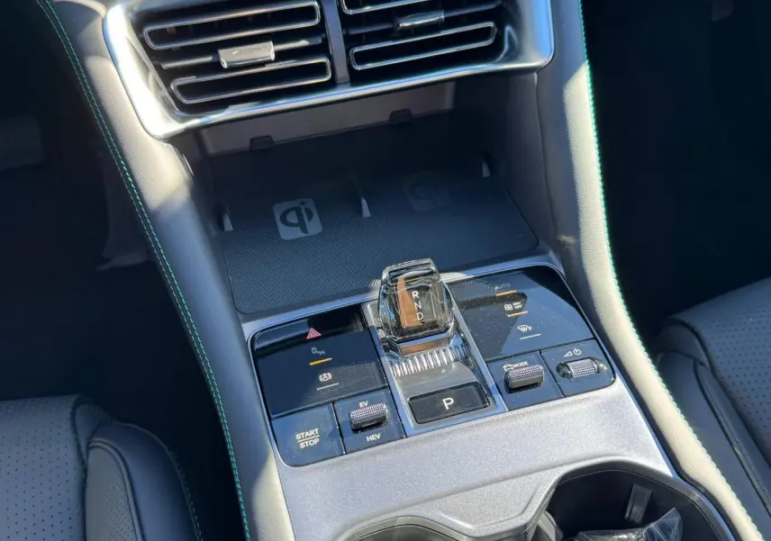 Vue rapprochée de la console centrale du BYD SEAL U 2026, avec levier de vitesses transparent et surpiqûres bleues.