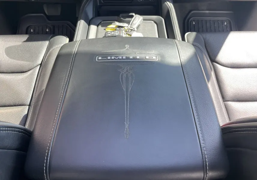 Vue rapprochée de la console centrale en cuir noir avec logo Limited du Dodge RAM 1500 5.7i 2020.
