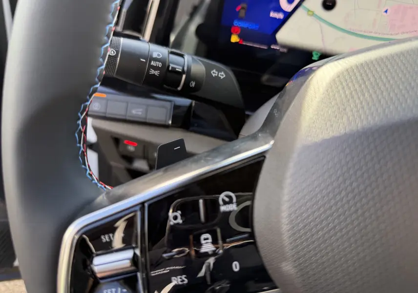 Gros plan sur la commande de régulateur de vitesse au volant cuir noir du Renault Austral blanc nacré toit noir 2025.