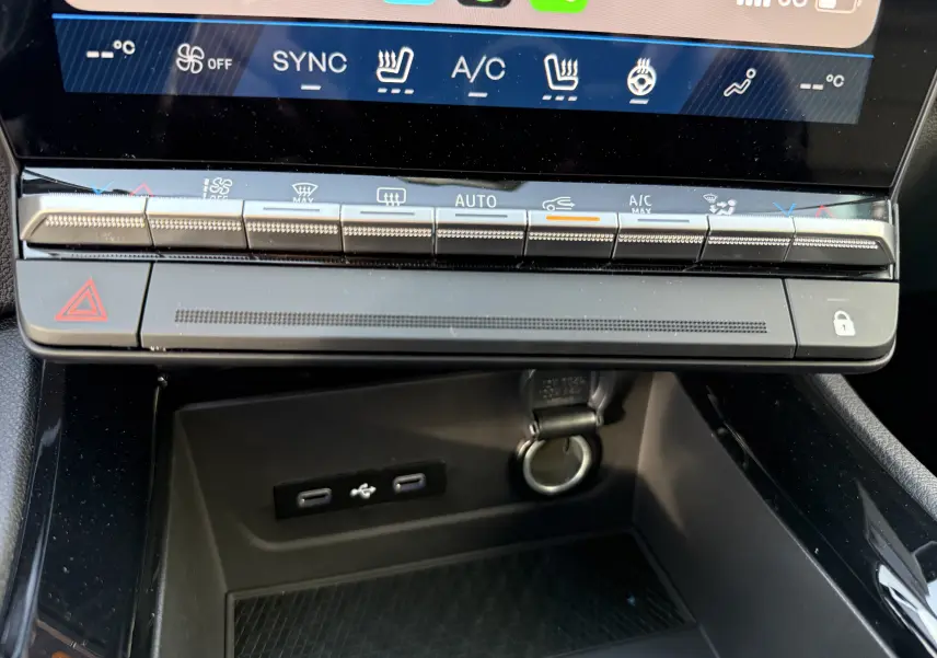 Vue rapprochée de la console centrale du Renault Austral 2025, montrant les commandes climatisation et ports USB sous l'écran tactile.