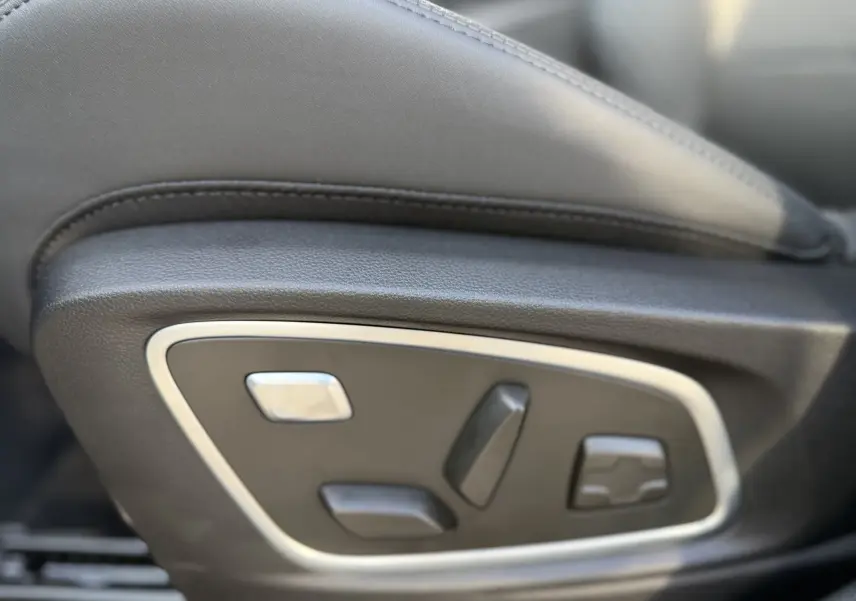 Gros plan sur les commandes de réglage électrique du siège avant en cuir noir du Renault Austral 2025.