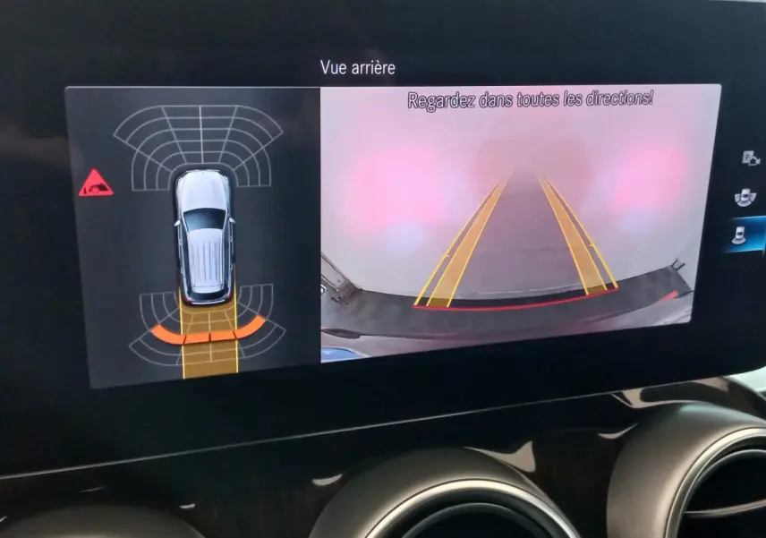 Affichage écran tactile intérieur montrant la caméra de recul et l'aide au stationnement du Mercedes GLC noir 2021.