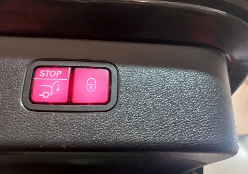 Boutons rouges stop et verrouillage du coffre sur le panneau intérieur d'un Mercedes GLC noir hybride rechargeable 2021.