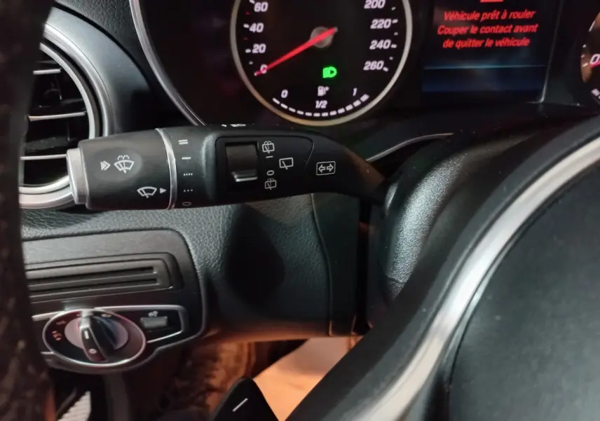 Gros plan sur le commodo gauche et tableau de bord du Mercedes GLC 300 E Business Line noir, affichage digital rouge visible.