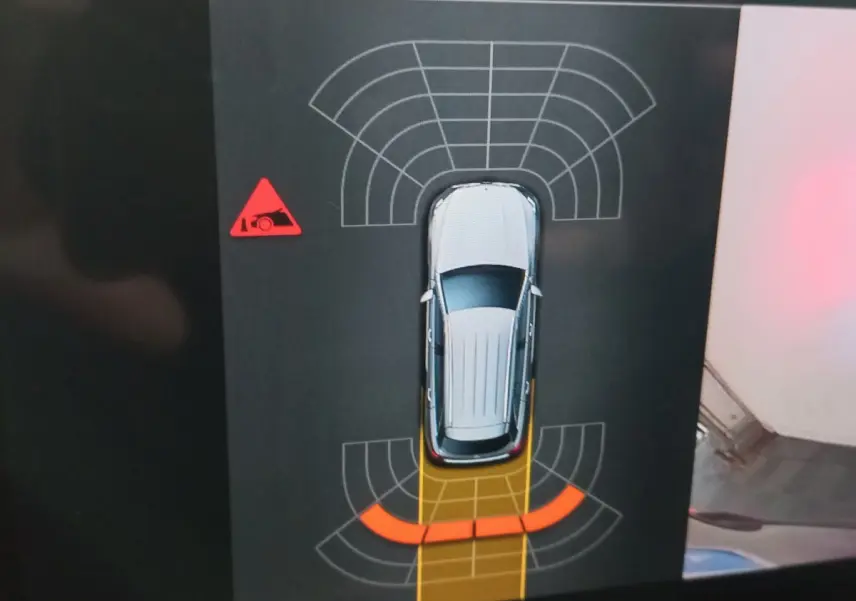 Vue de dessus de la Mercedes GLC noire affichée sur écran, avec alertes de capteurs de stationnement arrière activées.