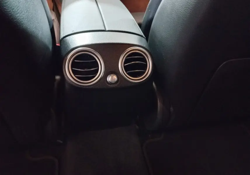 Détail des aérateurs arrière ronds chromés entre les sièges noirs du Mercedes GLC 300 E Business Line 2021.