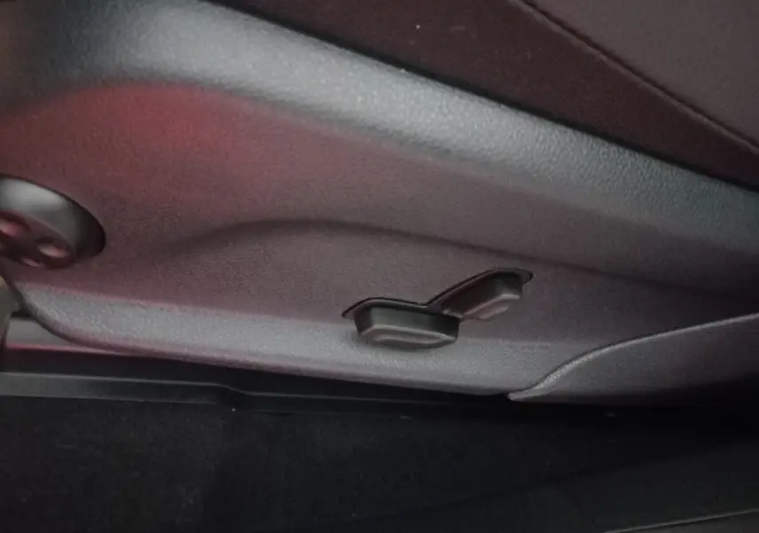 Détail des commandes de réglage manuel du siège en cuir noir dans un Mercedes GLC 300 E Business Line 2021.