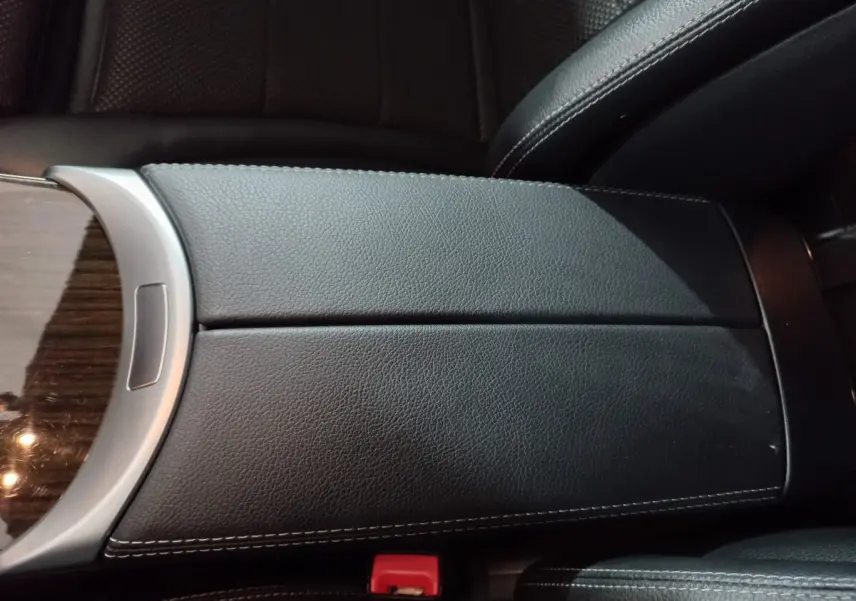 Gros plan sur l'accoudoir central en cuir noir avec surpiqûres blanches à l'intérieur d'un Mercedes GLC 300 E Business Line 2021.