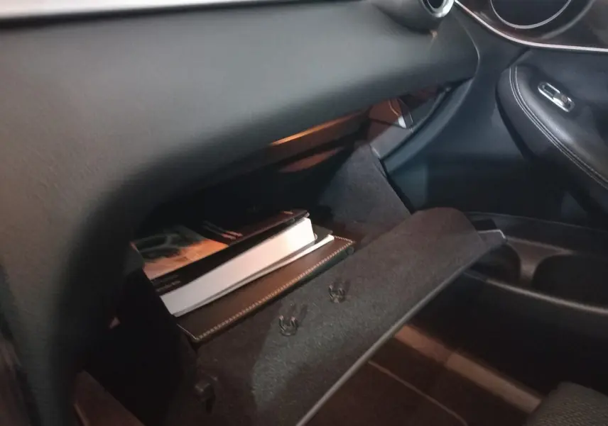 Gant de boîte à gants ouvert côté passager dans l'habitacle noir du Mercedes GLC 300 E Business Line 2021.