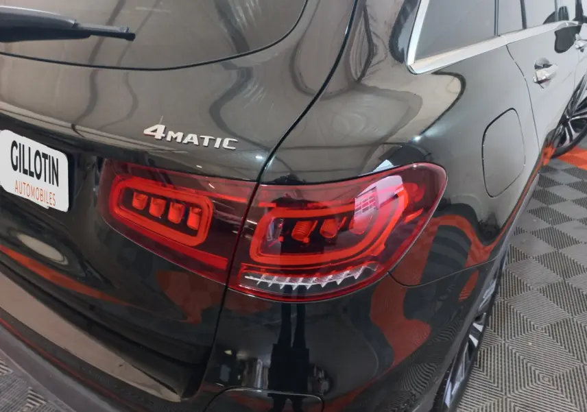Gros plan sur l'arrière droit noir brillant d'un Mercedes GLC 300 E 4MATIC avec feux arrière LED distinctifs.