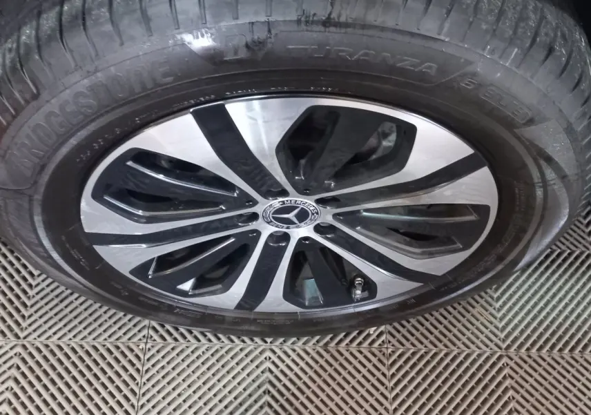 Gros plan sur la jante alliage bicolore noire et argentée d'un Mercedes GLC 300 E Business Line noir de 2021.