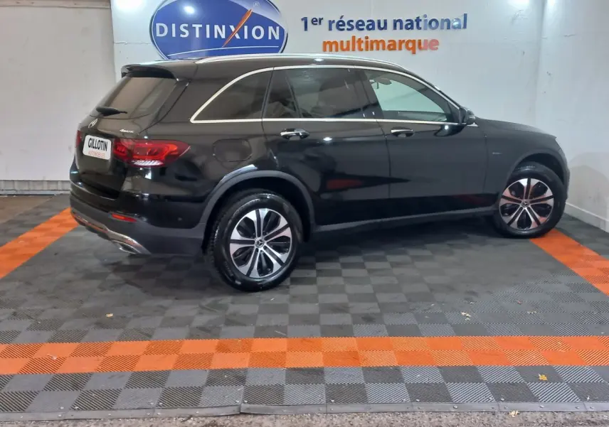 Vue de profil côté gauche d'un Mercedes GLC 300 E Business Line 4MATIC noir stationné en intérieur.