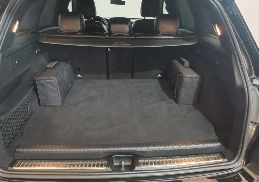 Coffre ouvert noir du Mercedes GLC 300 E Business Line 2021, vue arrière montrant espace et deux sacs noirs latéraux.