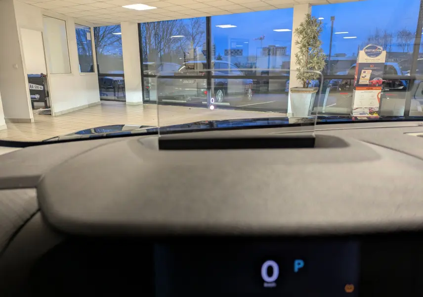 Vue intérieure du tableau de bord de la Citroën C4 hybride bleu nuit 2025, avec affichage tête haute et compteur digital.