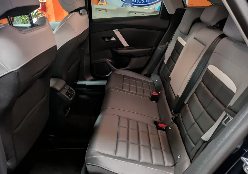 Vue intérieure arrière droite des sièges en cuir noir et gris de la Citroën C4 Hybride 145 e-DCS6 Max 2025.