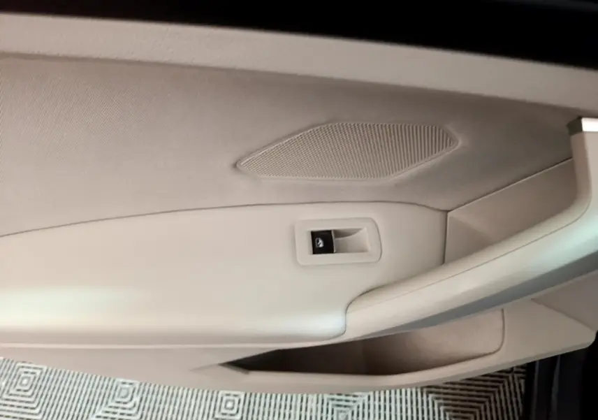 Détail de la porte intérieure beige clair du Volkswagen Tiguan 2022, avec commande de verrouillage visible.