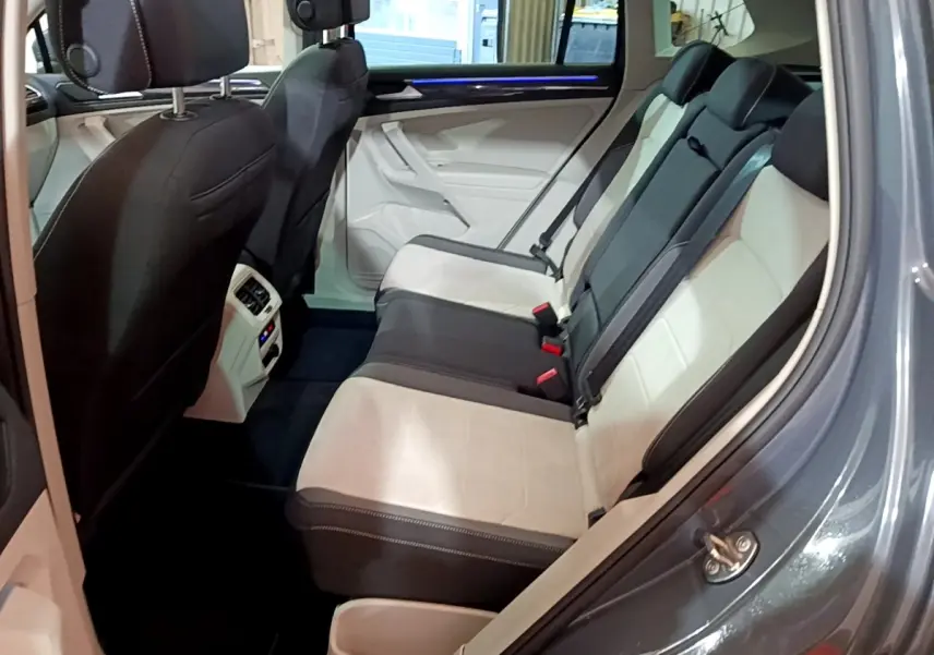 Vue intérieure côté droit des sièges arrière bicolores beige et noir du Volkswagen Tiguan gris clair 2022.