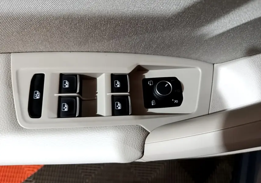 Commande des vitres électriques et réglage des rétroviseurs sur la porte côté conducteur du Volkswagen Tiguan gris clair 2022.