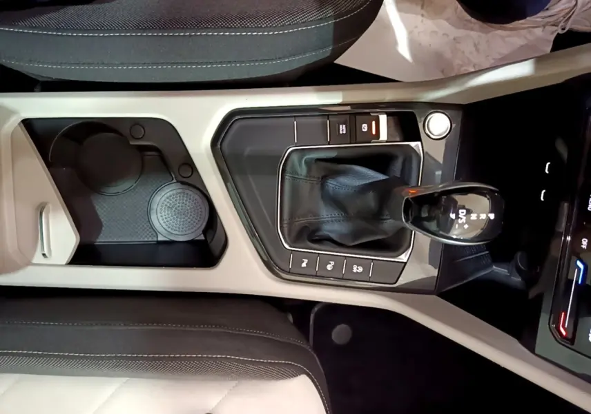 Vue plongeante sur la console centrale beige et noire du Volkswagen Tiguan 2.0 TDI 150 DSG7 avec levier de vitesse automatique.