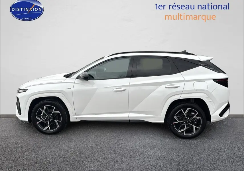 Vue de profil côté gauche du Hyundai Tucson blanc sérénité avec jantes alliage 19 pouces et toit noir contrasté.