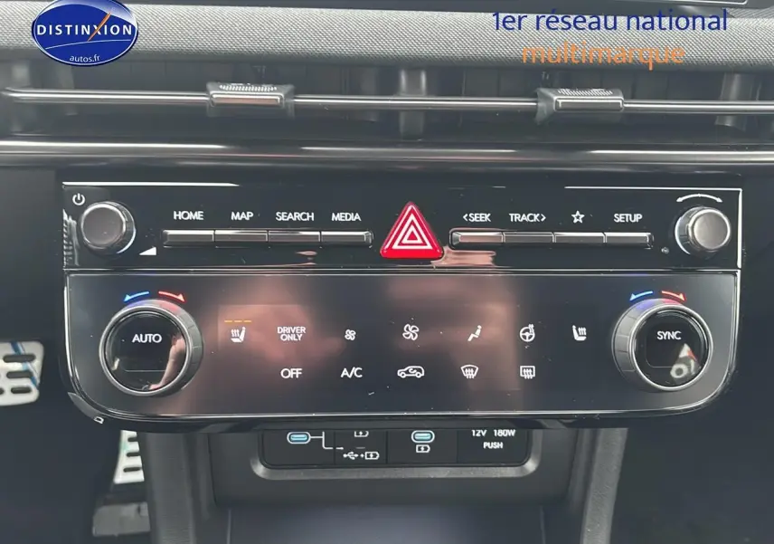 Vue rapprochée du tableau de bord du Hyundai Tucson 2026, montrant la console centrale avec commandes climatisation et multimédia.