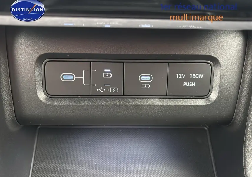 Gros plan sur la console centrale du Hyundai Tucson blanc sérénité, montrant les ports USB et prise 12V.