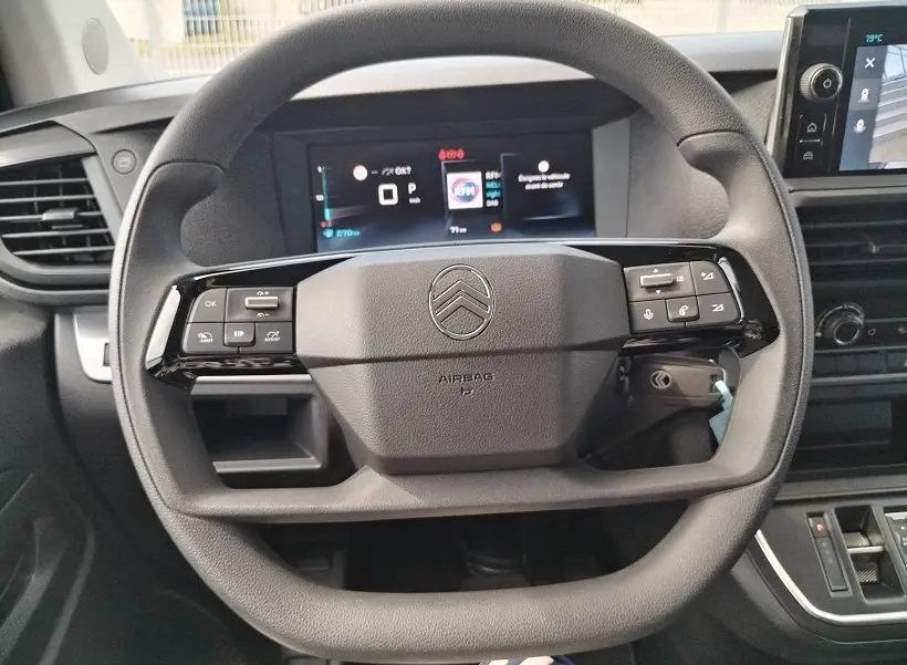Vue rapprochée du volant noir de la Citroën Jumpy Cabine Approfondie 2025 avec tableau de bord numérique en arrière-plan.