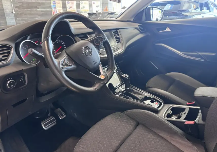 Intérieur avant d’un Opel Grandland 2019, vue côté conducteur montrant volant cuir multifonction et console centrale noire.
