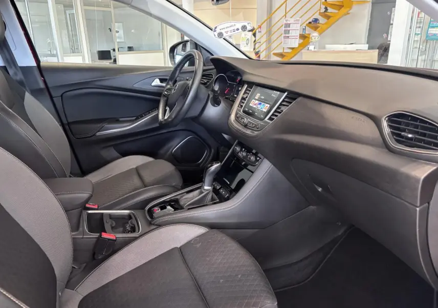 Intérieur Opel Grandland X 2019 vu côté conducteur, avec tableau de bord noir et console centrale équipée d'une boîte automatique.