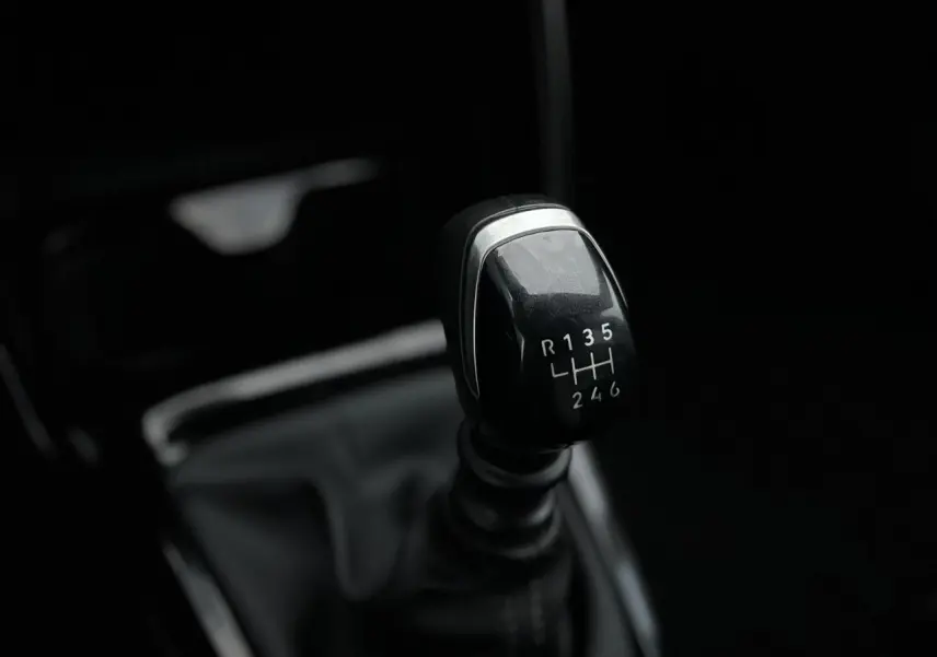 Gros plan sur le levier de vitesses manuel noir de la Citroën C3 Turbo 100 Max, intérieur sombre et épuré.