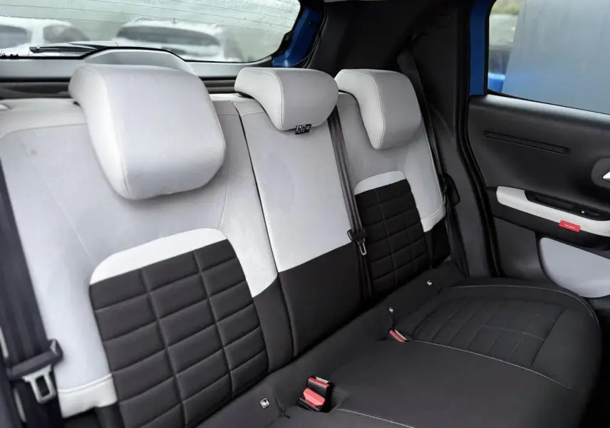 Vue intérieure du siège arrière bicolore noir et gris de la Citroën C3 Turbo 100 Max, avec appuie-têtes et ceinture de sécurité.