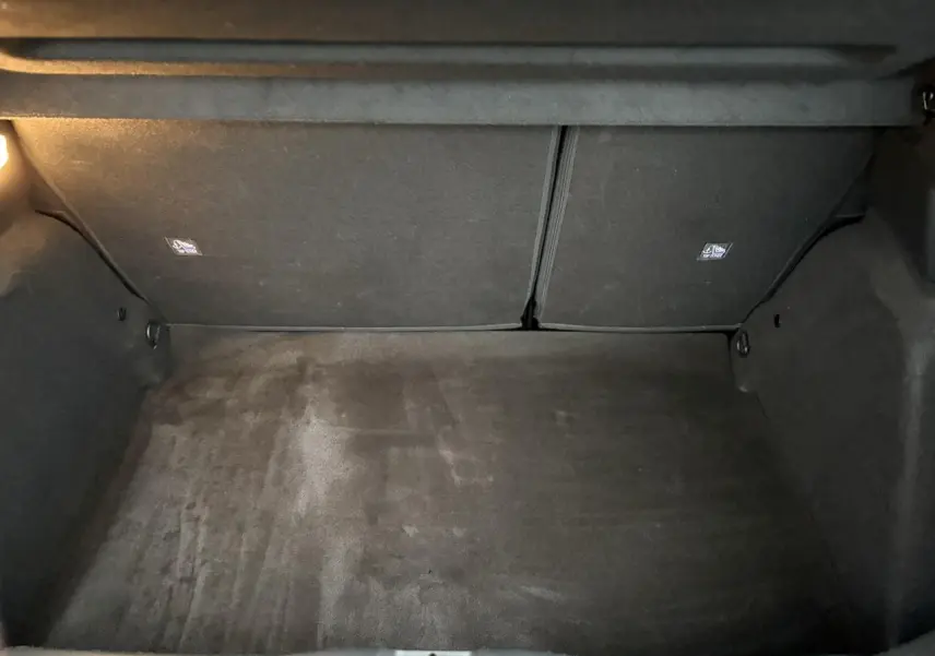 Coffre vide de Citroën C3 Turbo 100 Max 2025, vue intérieure avec tapis noir et éclairage latéral.