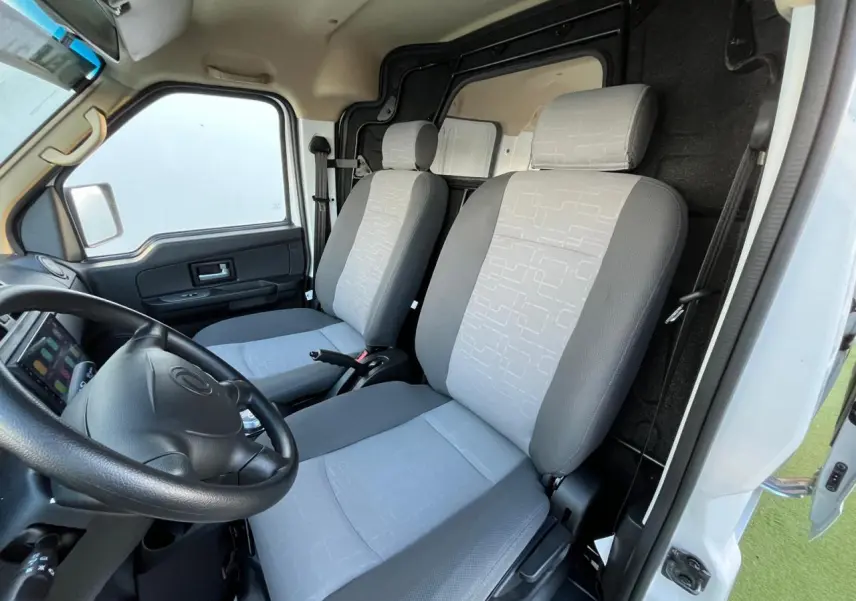 Intérieur du fourgon SERES DFSK EC35 blanc, vue côté conducteur montrant les sièges gris et le volant noir.