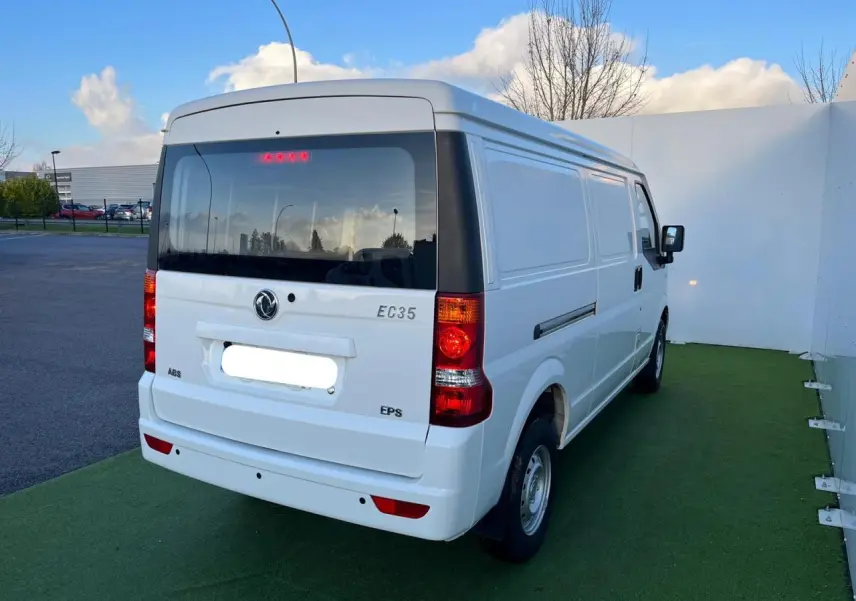 Vue arrière droite du fourgon blanc SERES DFSK EC35 électrique 2022 avec vitres teintées et feux arrière allumés.
