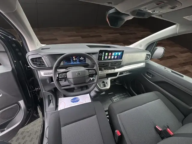 Intérieur du Citroën Jumpy 2025 en vue frontale, tableau de bord moderne avec écran tactile et sièges tissu noir.