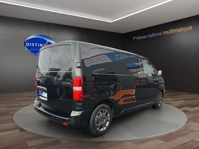 Vue 3/4 arrière droite du Citroën Jumpy noir 2025, fourgon compact avec jantes spécifiques et vitres teintées.